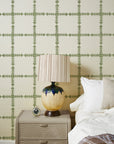 Green geometric grasscloth wallpaper with cross lattice pattern behind bed
