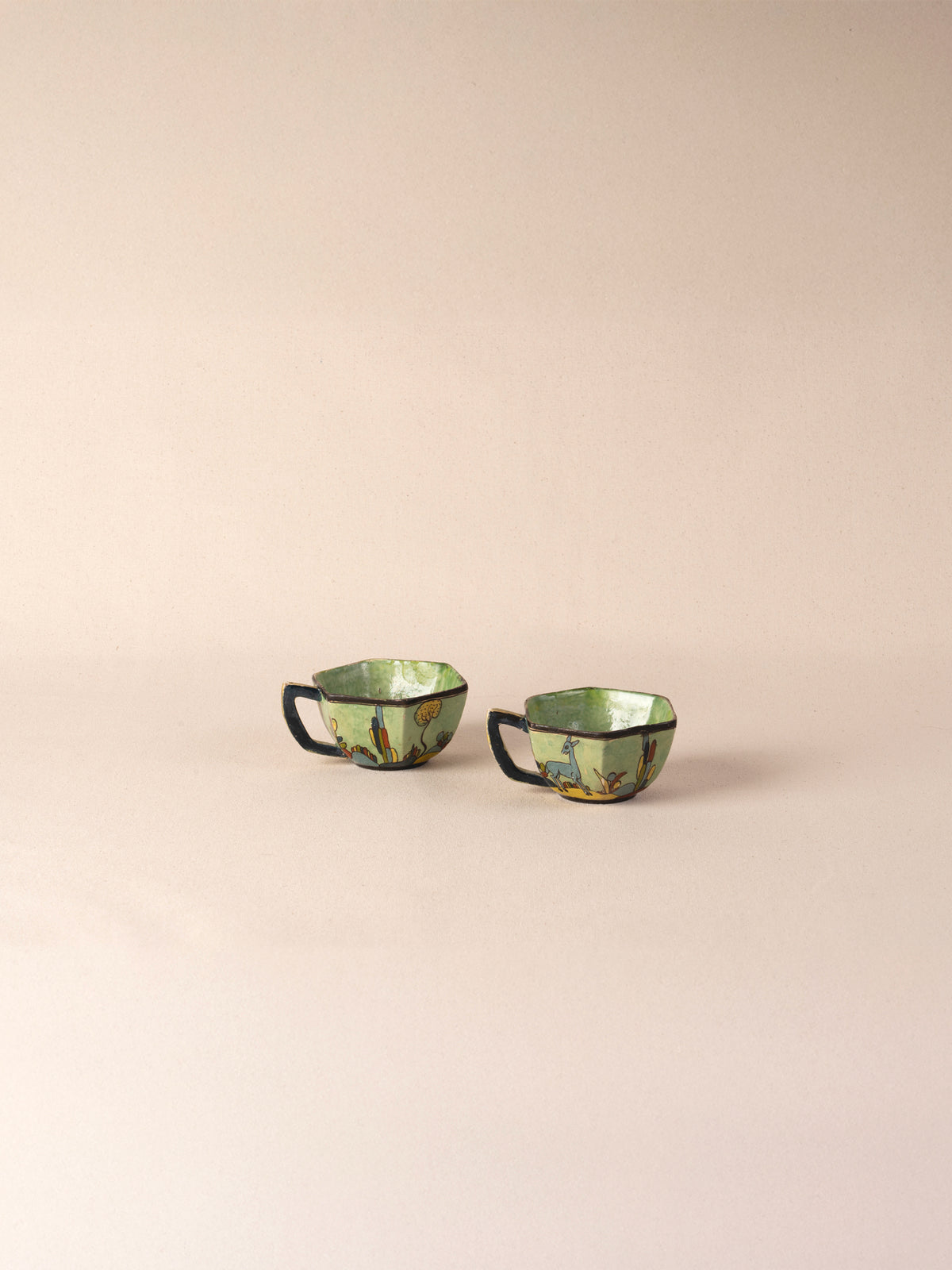 Pair of vintage Mexican ceramic teacups painted with a colorful desert landscape