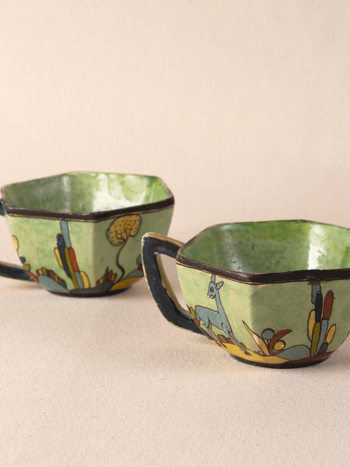 Pair of vintage Mexican ceramic teacups painted with a colorful desert landscape