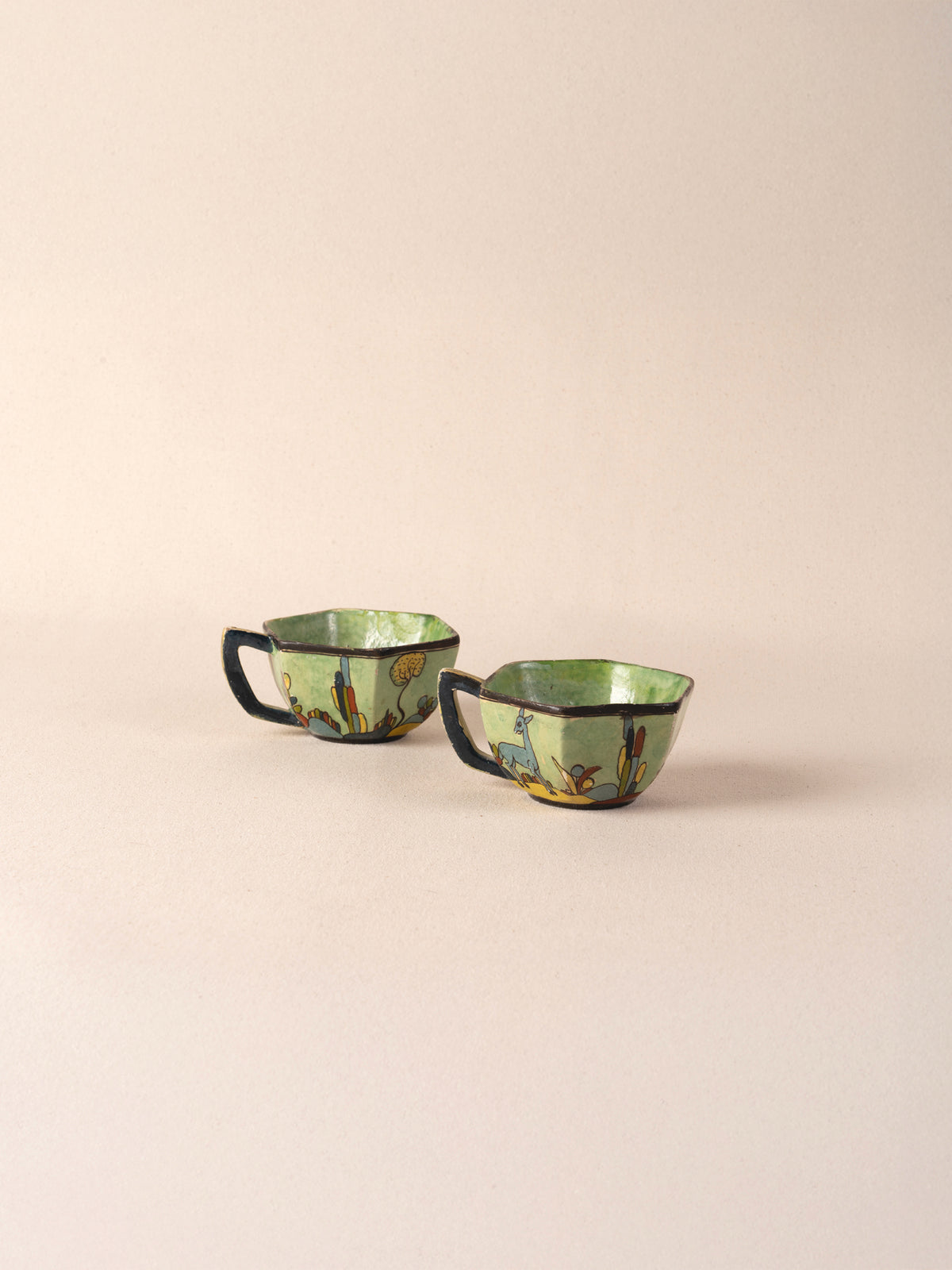 Pair of vintage Mexican ceramic teacups painted with a colorful desert landscape