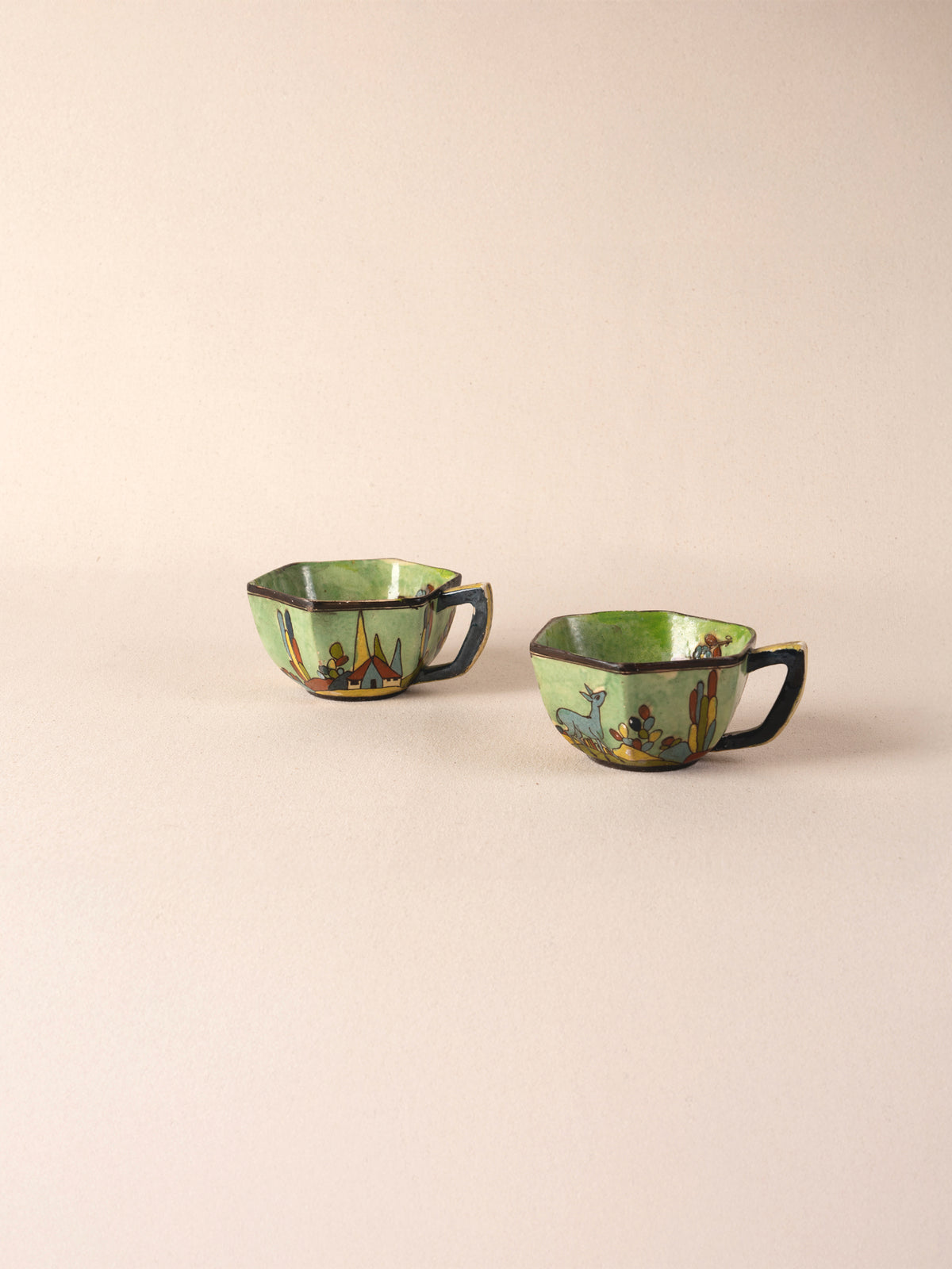 Pair of vintage Mexican ceramic teacups painted with a colorful desert landscape