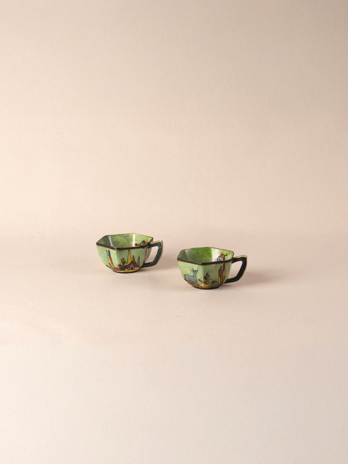 Pair of vintage Mexican ceramic teacups painted with a colorful desert landscape