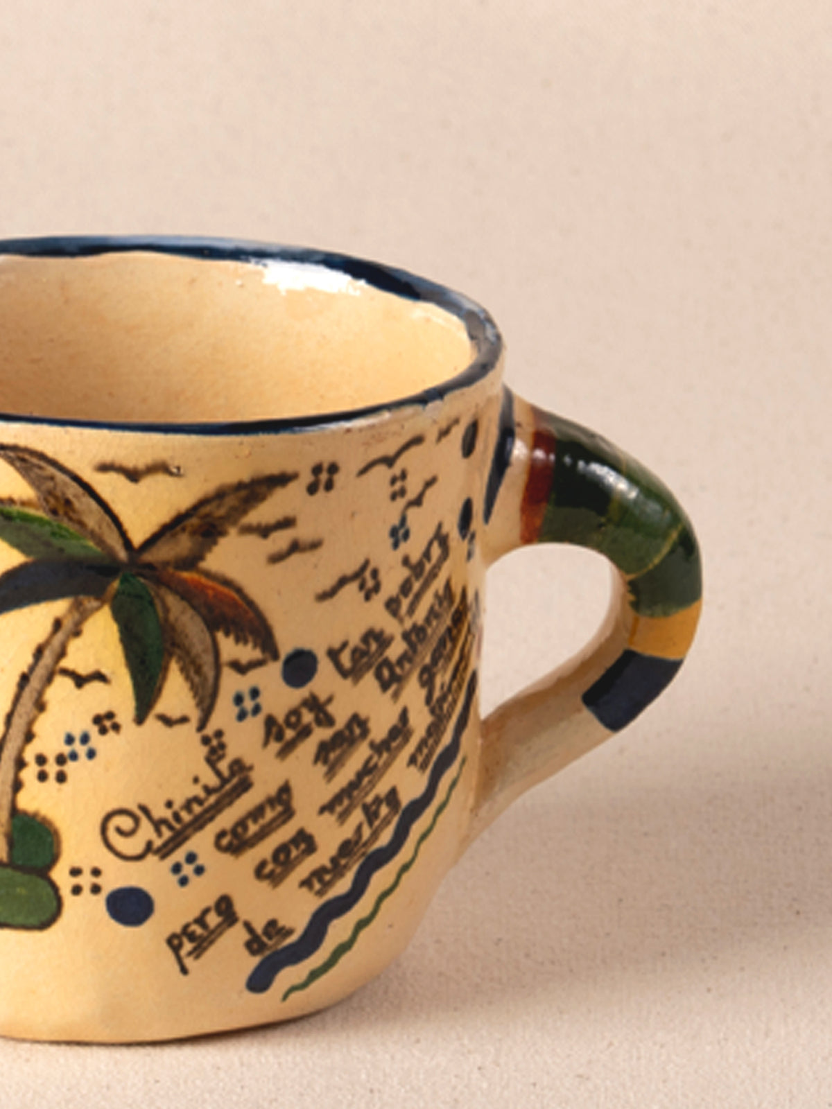 Hand-painted vintage Mexican ceramic teacup with a multicolor striped handle