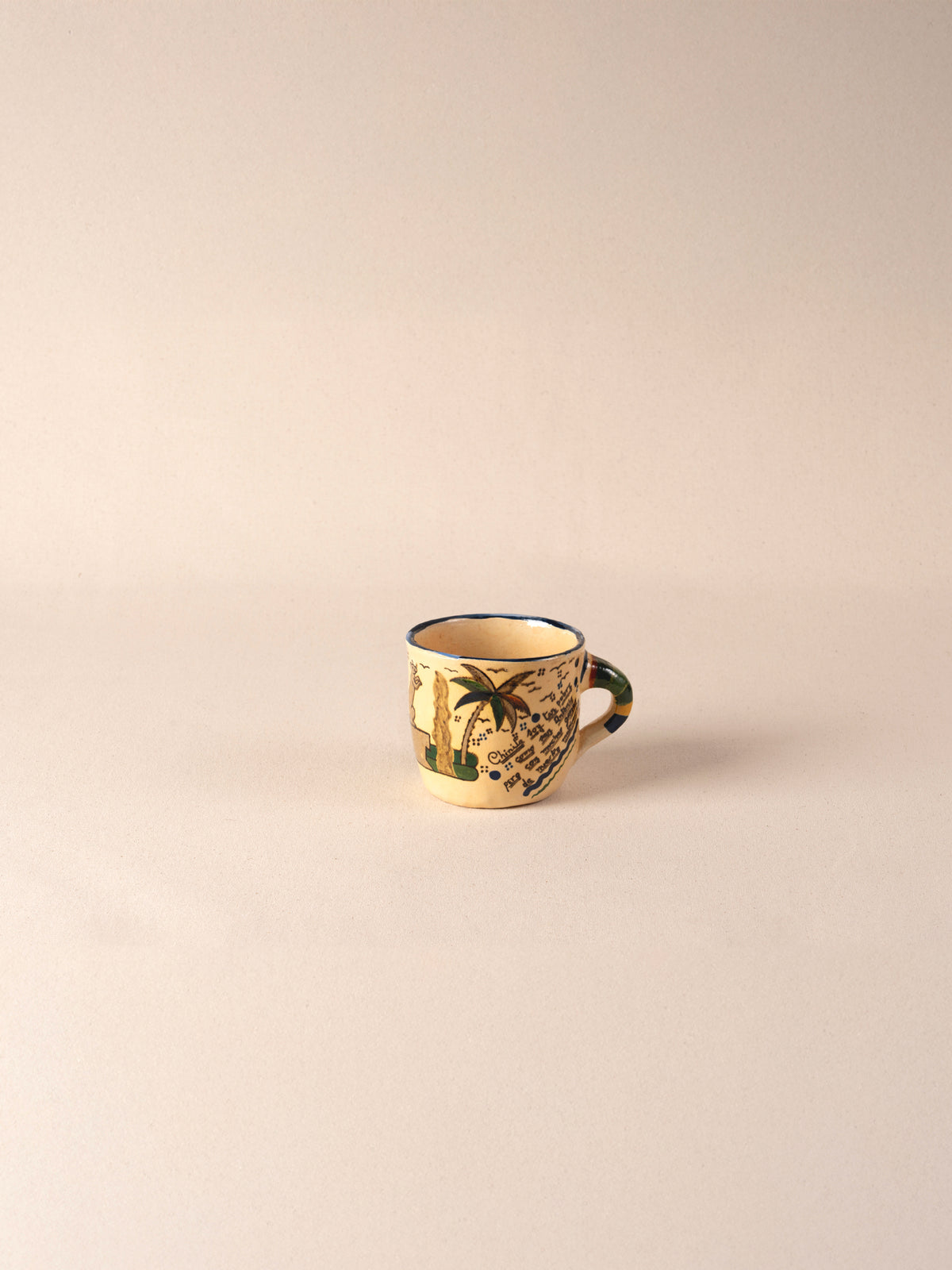 Hand-painted vintage Mexican ceramic teacup with a multicolor striped handle