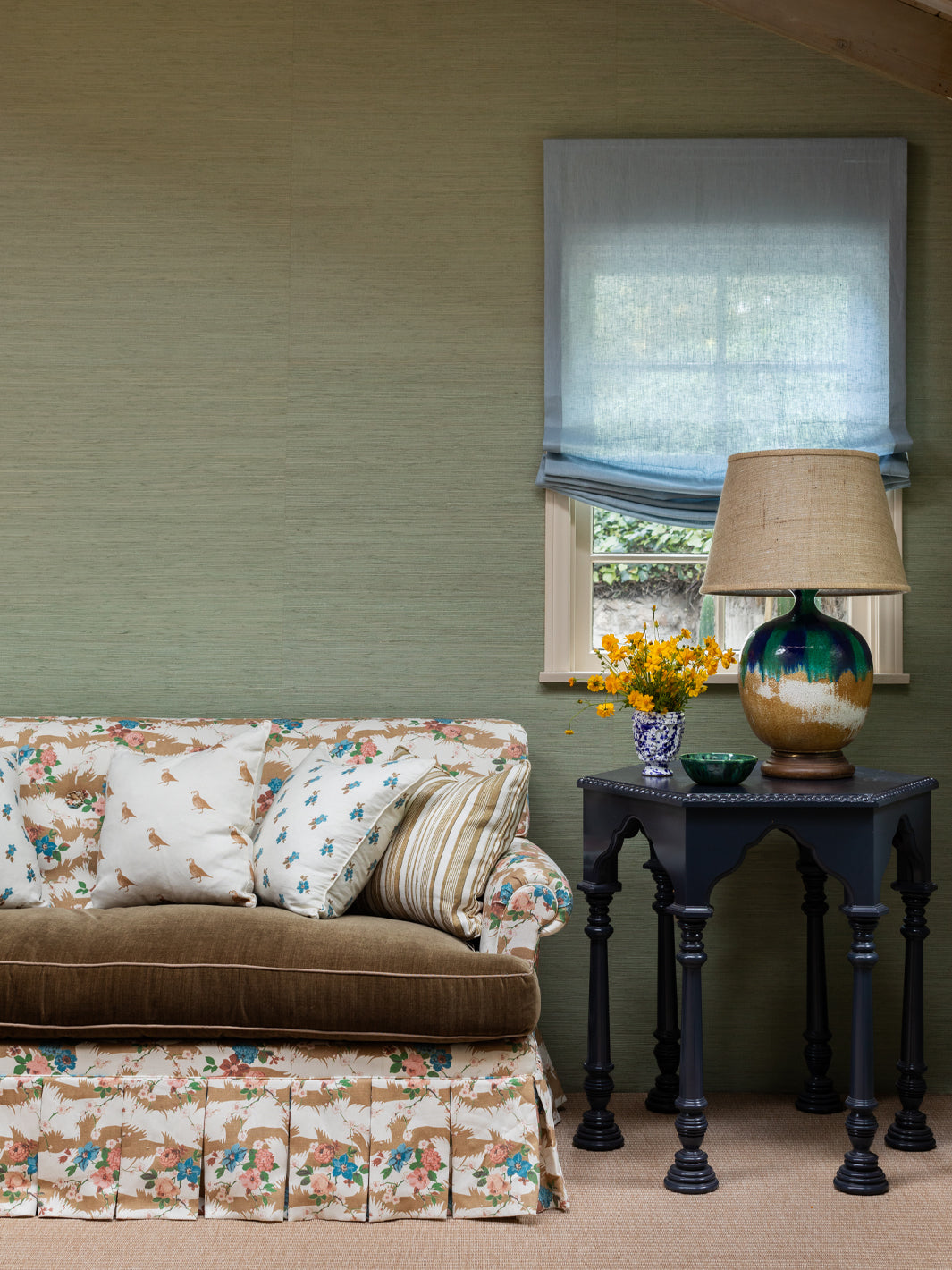 Floral chintz upholstery fabric on sofa cushions, beige ground with blue and pink blooms