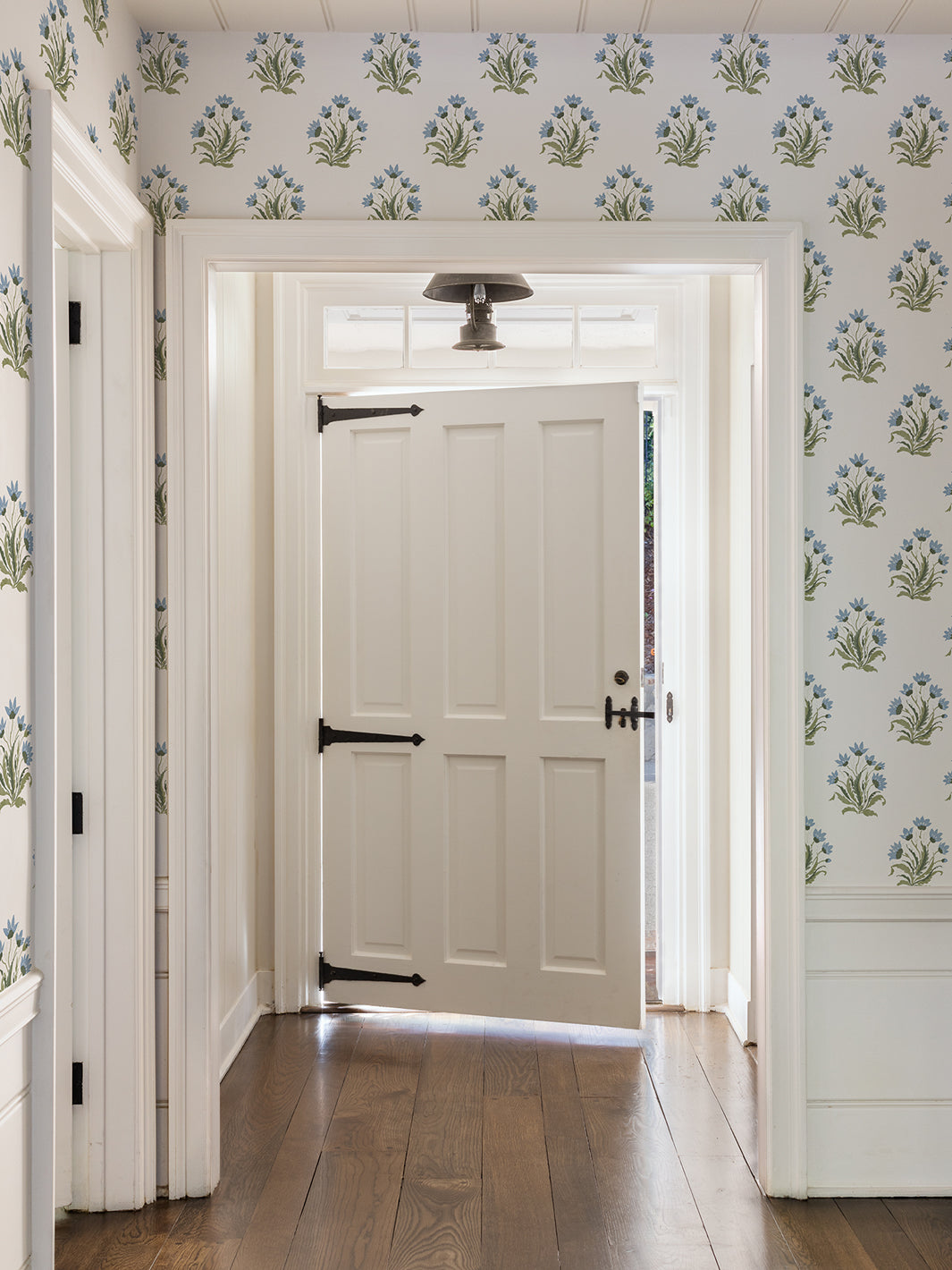 Installed wallpaper with repeating blue and green floral block print on hallway walls