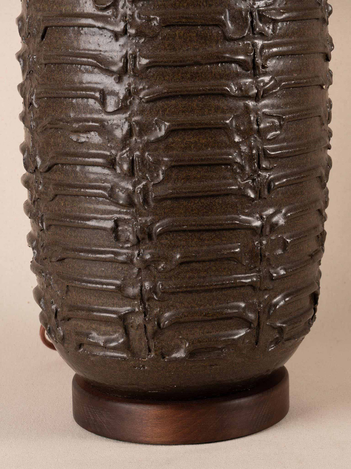 Mid-century brown ceramic table lamp with a textured, ribbed geometric base and burlap shade