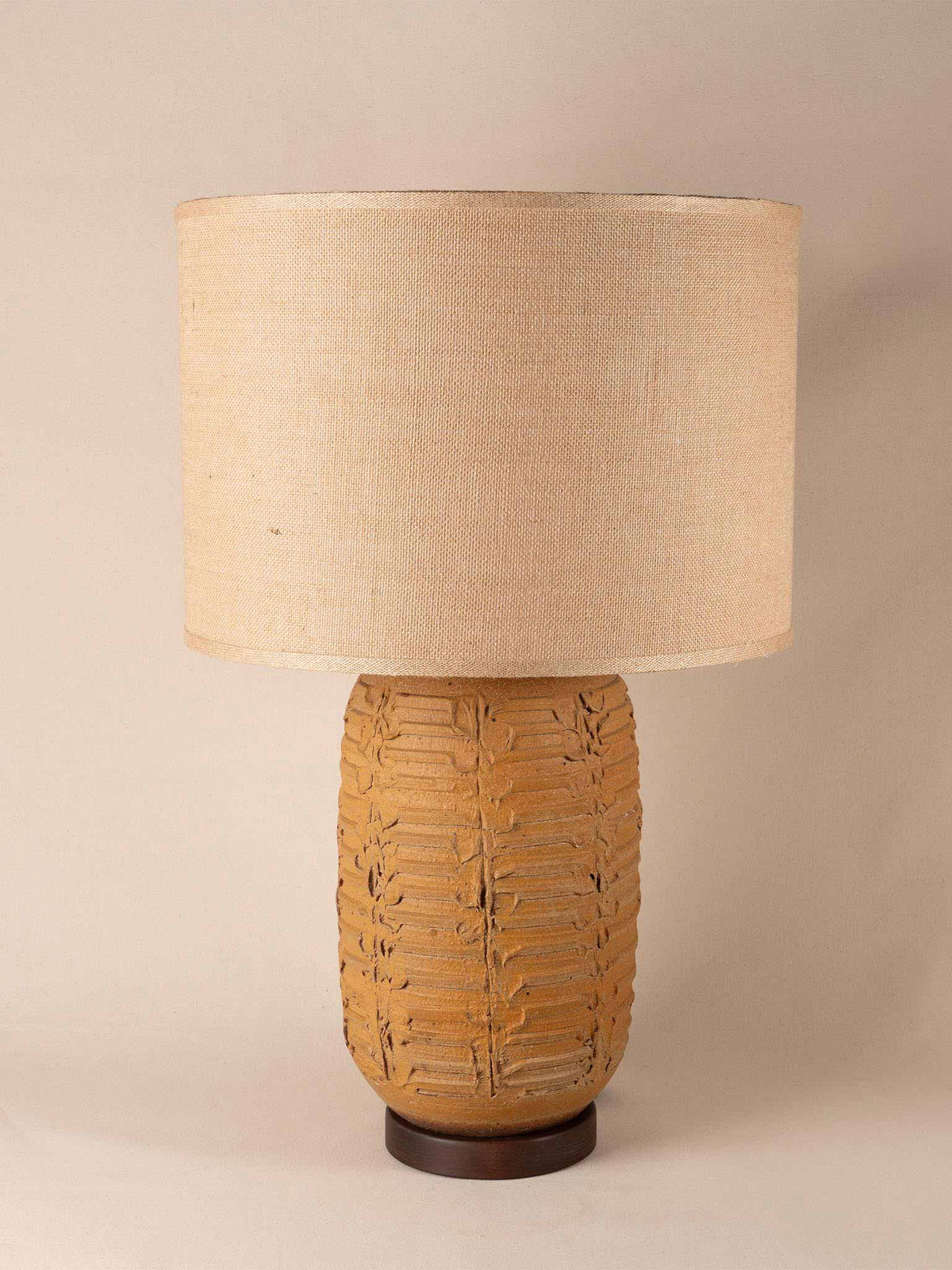 Tall mid-century yellow ceramic table lamp with a textured, ribbed geometric base and burlap shade