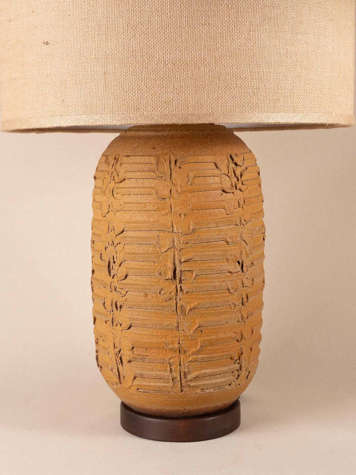 Tall mid-century yellow ceramic table lamp with a textured, ribbed geometric base and burlap shade