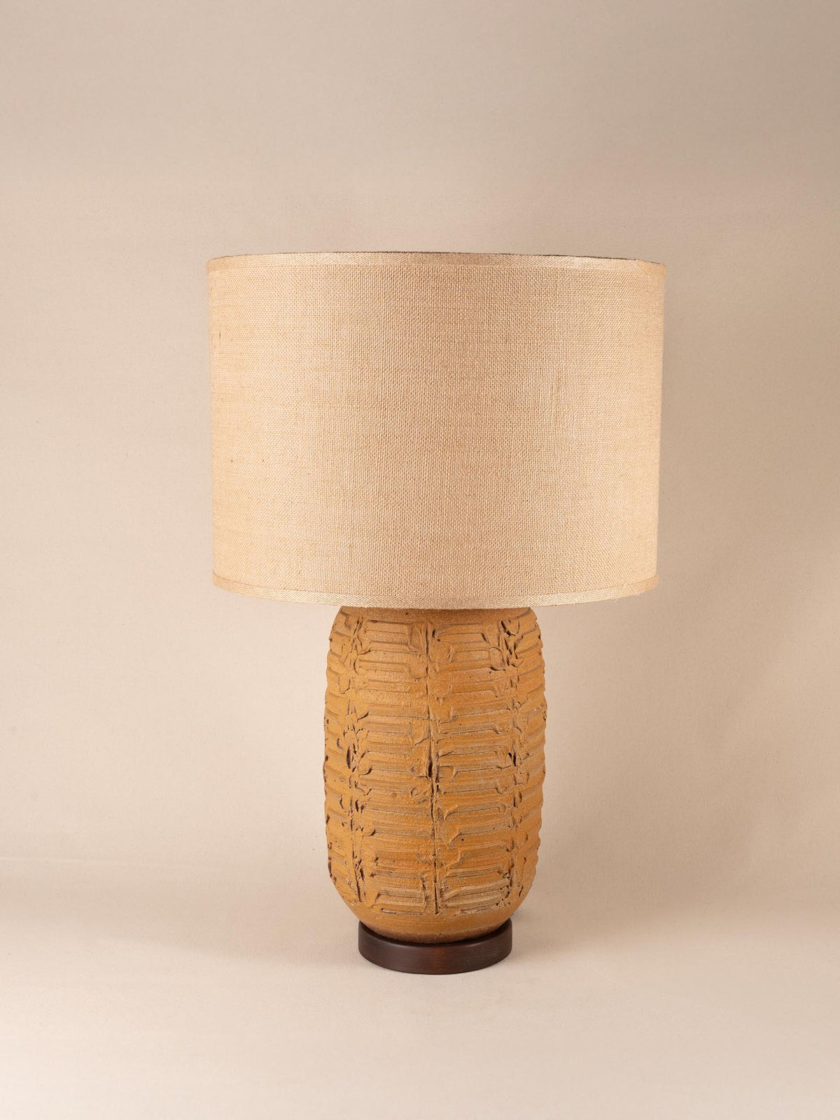 Tall mid-century yellow ceramic table lamp with a textured, ribbed geometric base and burlap shade