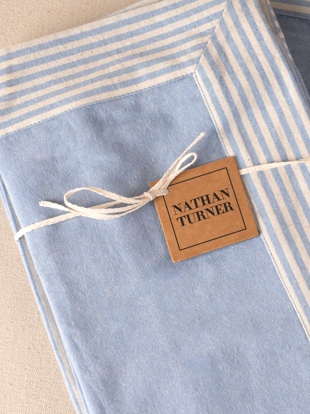 Four folded cotton napkins in chambray tones
