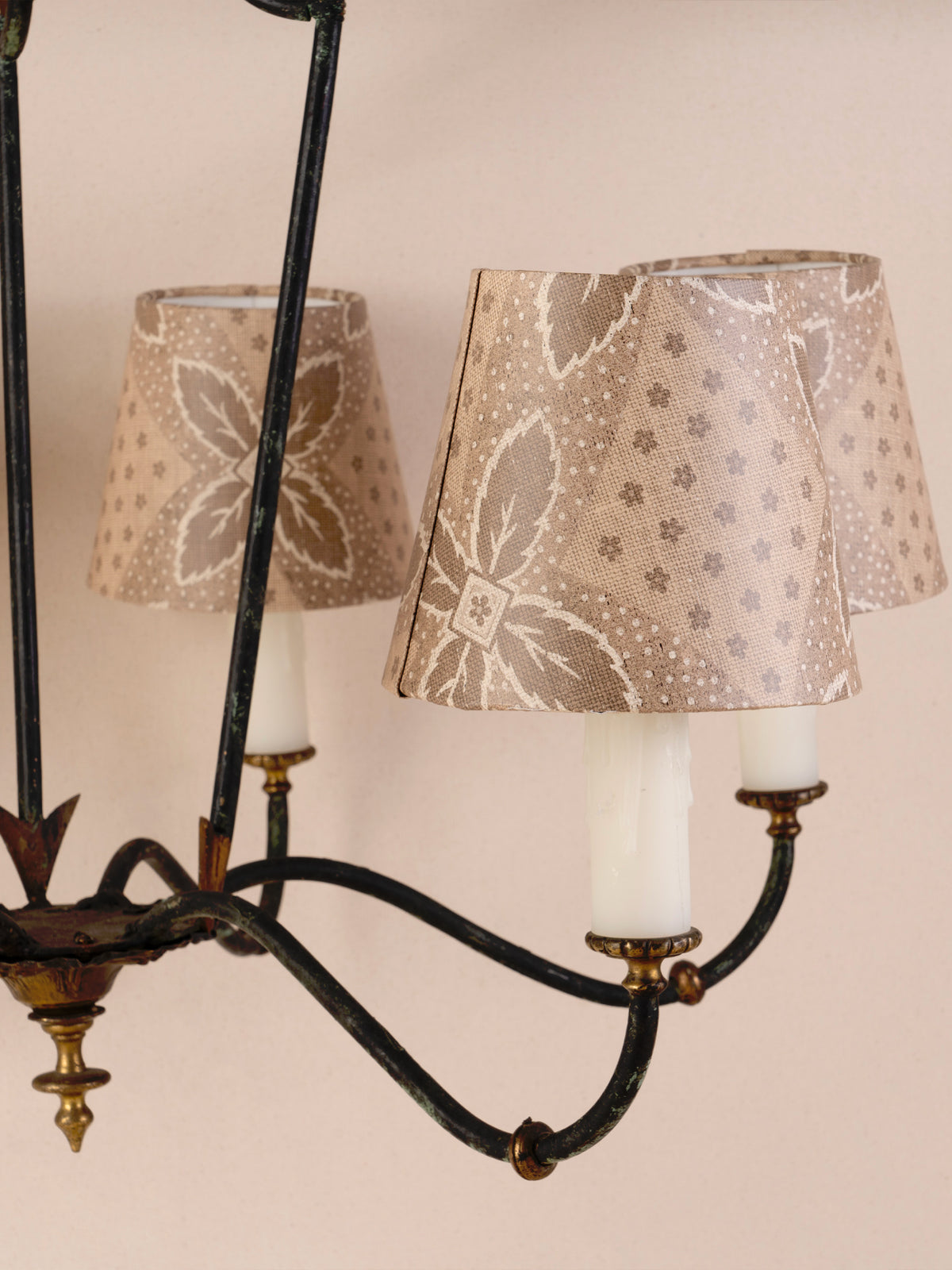 Antique three-arm dark iron chandelier with small linen shades