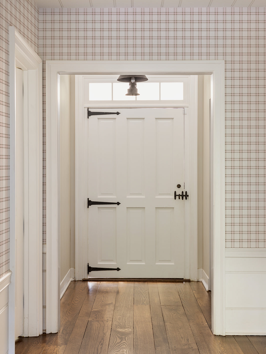 Plaid wallpaper on hallway walls with white, brown, and pink checkered pattern